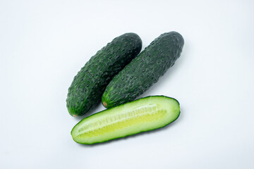 Cucumbers on a white background. The cucumber is cut lengthwise. Fresh ripe cucumbers.