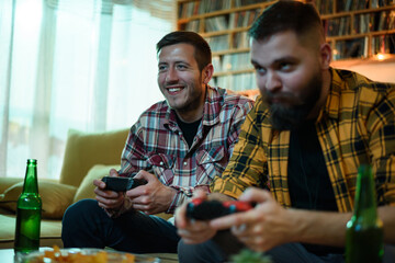 Two best friends playing video games while relaxing at home