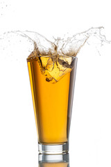 splash from falling ice into glass with foamy beer on white background isolated