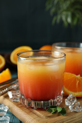 Tequila Sunrise cocktails and ingredients on wooden table