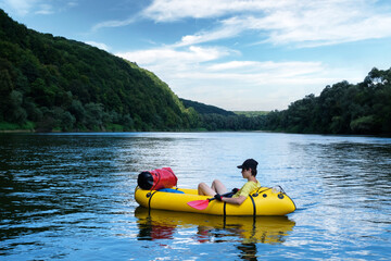 Tourist on yellow packraft rubber boat with red padle