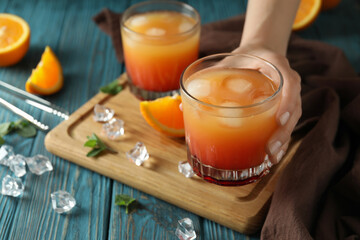 Concept of preparing Tequila sunrise cocktail on wooden table