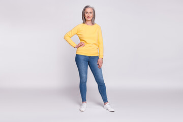 Fototapeta na wymiar Full size photo of happy good looking lovely grandmother wear yellow sweater and jeans isolated on grey color background