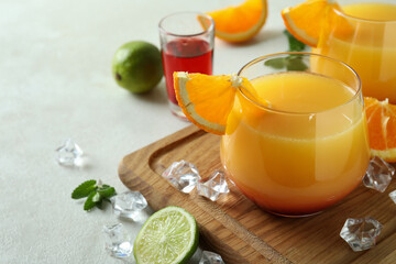 Board with Tequila Sunrise cocktails on white textured table