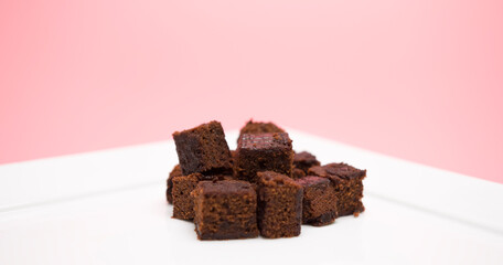 Brownies in a white plate isolated on pink background,  Food concept Front view.