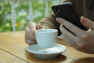 Man drink coffee and holds phone, close up