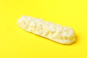 Tasty white candy bar on yellow background