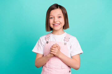 Photo of cheerful happy nice small girl good mood hold hands dream wish isolated on teal color...