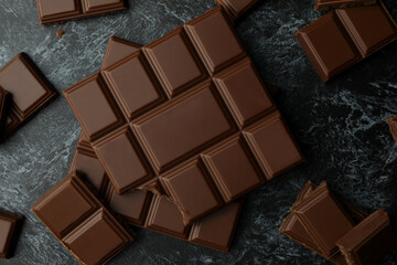 Tasty chocolate bars on black smokey background