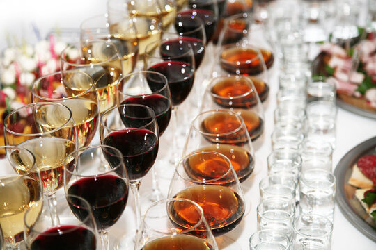 Buffet table on party. Rows of glasses of red wine, champagne, cognac, water and vodka. Drinks in glasses at a furshet