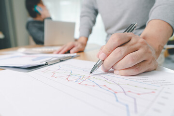 Hand of businessman point to graph. is discussing together in conference room talk about Report, Sales, Target, Marketing,