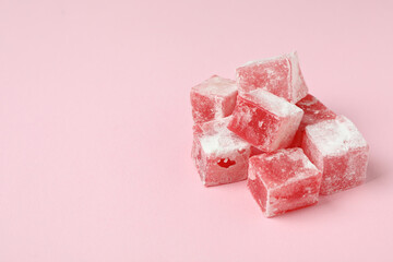 Delicious turkish delight cubes on pink background