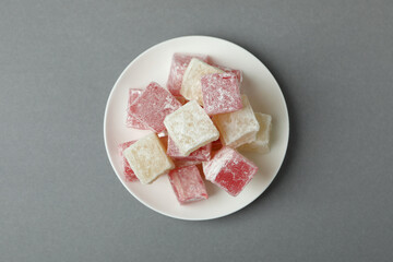 Plate with delicious turkish delight on gray background