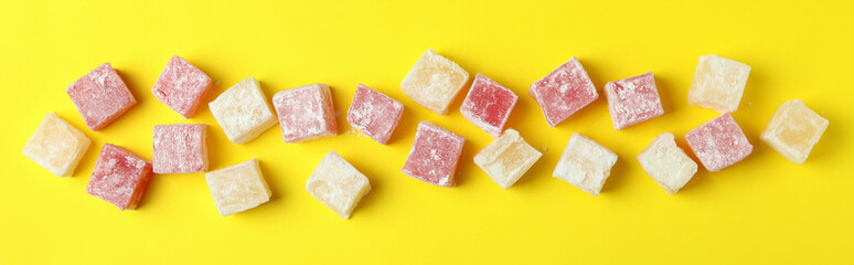 Delicious turkish delight on yellow background, top view