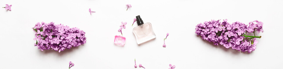 Naklejka na ściany i meble Spring flowers. Floral scent concept. elegant Perfume bottle with lilac flowers over white background. Top view, flat layer. Banner
