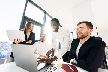 Happy office employee working together on laptop