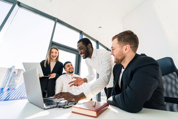 Fototapeta premium Cheerful business people in the office working on a new task together