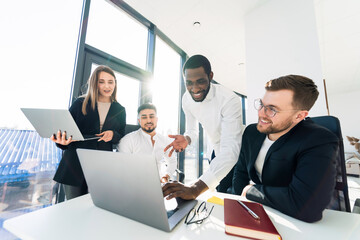 Group of multi-ethnic young software developers working at the computer