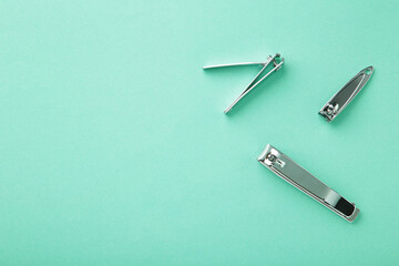 Fototapeta premium Nail clippers on a mint background. Minimalism