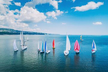 Regatta sailing ship yachts with white sails at opened sea. Aerial view of sailboat in windy...