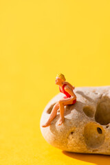 miniature woman in swimsuit on a rock