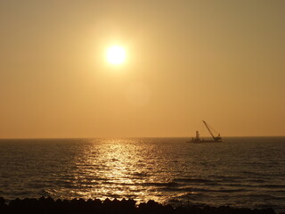 Fototapeta na wymiar 日本海に沈む夕日と船