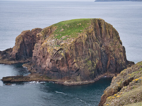 The red granite Groni Stack, near The Nev at Westerwick, Mainland, Shetland, UK - Sandsting Pluton - Granite. Igneous Bedrock formed approximately 359 to 393 million years ago in the Devonian Period.