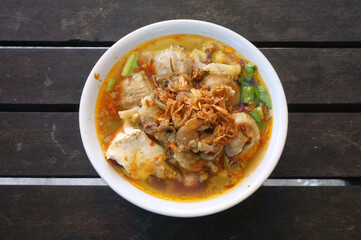 Bakso setan (Indonesian). Super spicy meatballs soup with noodles, Chicken feet, tofu and beef fat. Selective focus.     