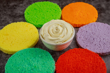 Colorful rainbow layer birthday cake in process.