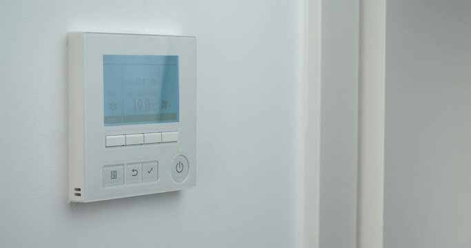Woman hand changing temperature in remote controller of air conditioner to cold
