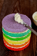 Making rainbow layer cake with white cream.
