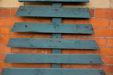 wooden slats attached to a red brick wall