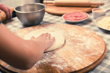 Kneading the pizza dough. Pizza master class in a pizzeria.