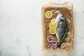 Raw Dorado fish on an old wooden cutting board prepared for cooking.
