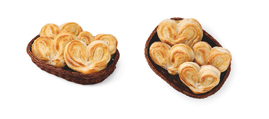 Heart-shaped sweet dough buns with sugar lie in a wicker basket and are isolated on a clean white background with small soft shadows.