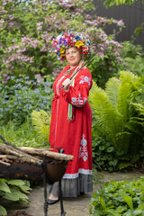 Ukrainian woman in a red national costume in the garden in summer
