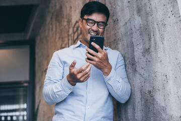 asian man work using cell phone hand holding mobile texting message contact us.chatting,search internet information in office.technology device communication connecting
