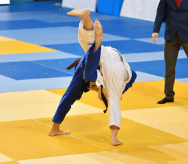 Two Girls judoka in kimono compete on the tatami 