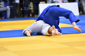 Two Girls judoka in kimono compete on the tatami 