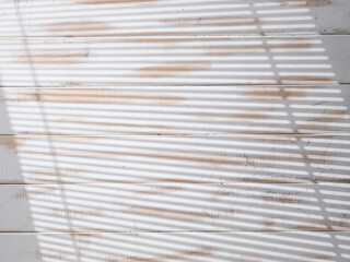 White wooden texture with light from the window through the blinds
