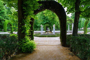 Nice corner of public park with old white stone columns and seating for lounging. Aranjuez.