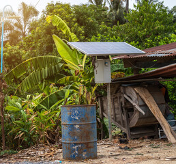 Solar panel in a rural houses area and old oil barrels are ready to recycle Industrial,Agro-industry of household Rural style in Thailand, Alternative energy concept