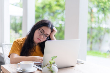 Fototapeta premium Stressed of freelance people business female wearing protective mask casual having a headache after business losses working with laptop in coffee shop background,working from home,Concept of COVID-19