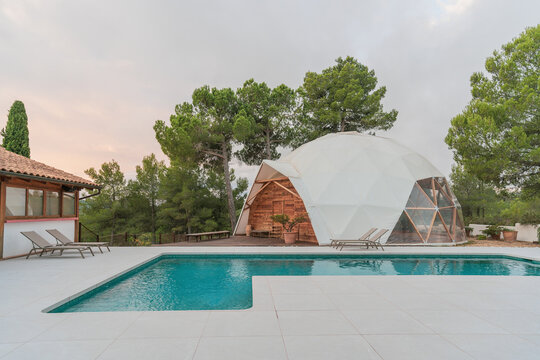 Domed yoga room by pool with crystal water
