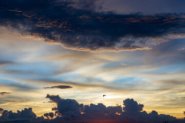 Obraz premium Twilight blue bright and orange yellow dramatic sunset sky in countryside or beach colorful cloudscape texture with white clouds air background.