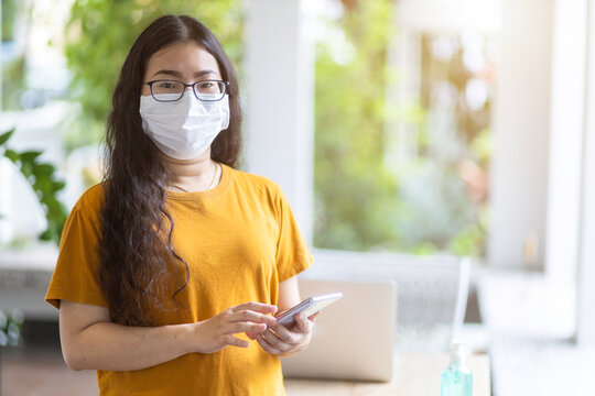freelance people business female wearing protective mask casual and writing message on smartphone working with laptop computer ,working from home,Concept of Prevention of the spread of COVID-19 virus