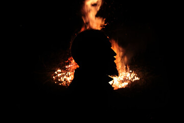 Profile of a man with a beard against the background of fire - obrazy, fototapety, plakaty