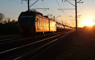 Fototapeta na wymiar Train with tanks with oil products on the background of sunset