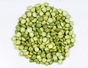 pile of dried green split peas close up on gray