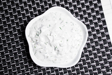 sauce for sushi rolls in a plate on an isolated background with herbs and spices
